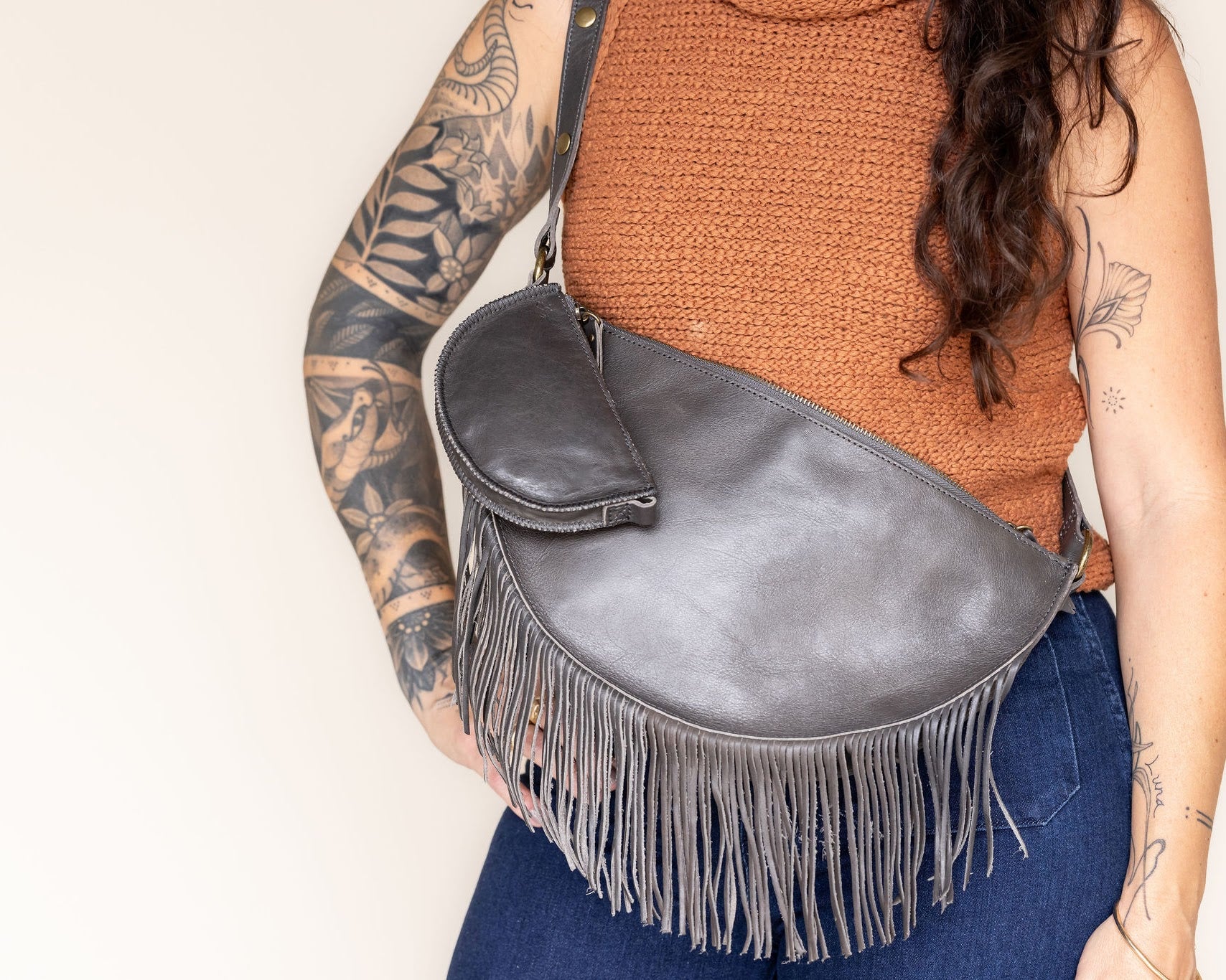 Mini charcoal leather pouch clipped to a charcoal leather fringe bag