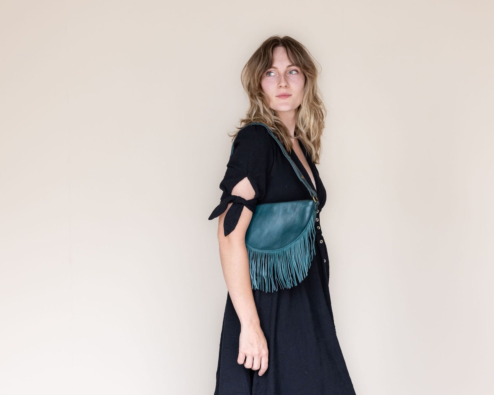 Small teal leather fringe bag, side view
