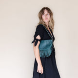 Small teal leather fringe bag, side view