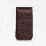 A dark brown leather phone pouch with a stitched border, shown flat against a textured white background.