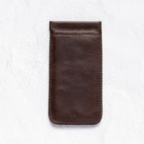 A dark brown leather phone pouch with a stitched border, shown flat against a textured white background.