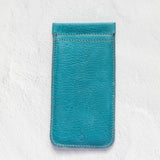A teal blue leather phone pouch with matching stitching, displayed flat against a textured white background.