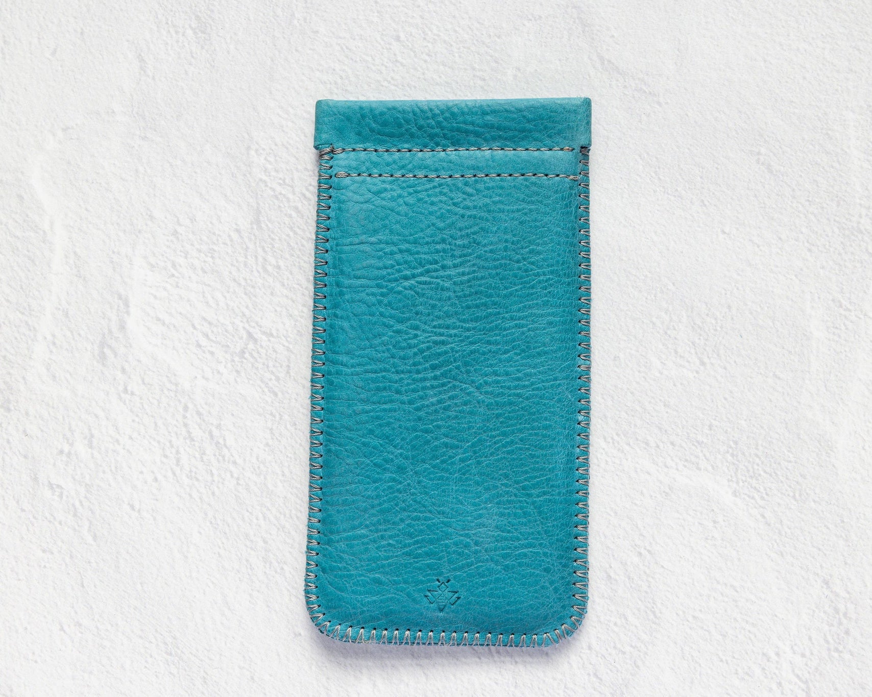 A teal blue leather phone pouch with matching stitching, displayed flat against a textured white background.