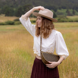 Woman wearing the Woven Sage & Espresso Queen Bee crossbody