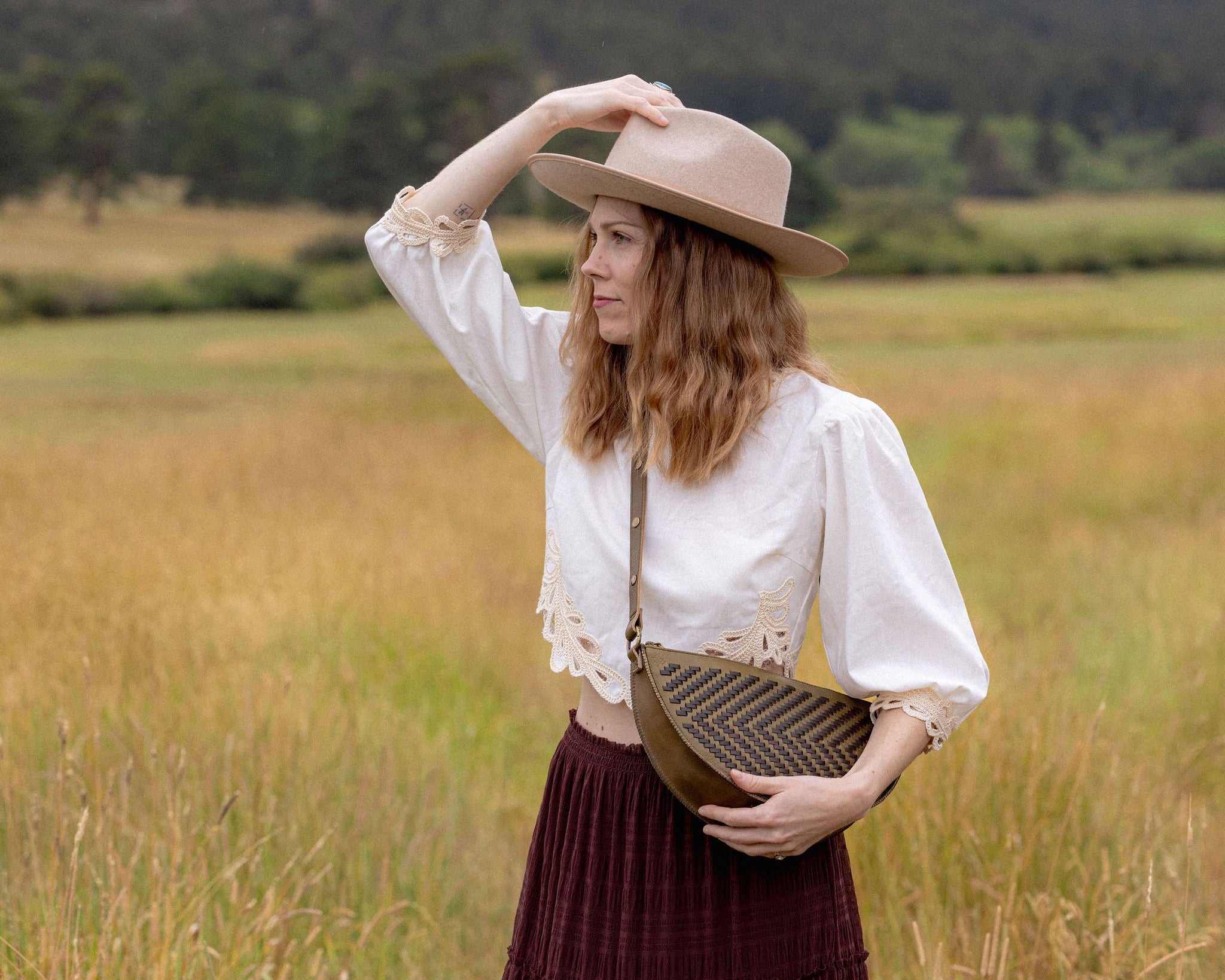 Woman wearing the Woven Sage & Espresso Queen Bee crossbody