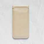 A minimalist beige leather phone pouch or card holder with a single horizontal card slot, shown flat against a textured white background.