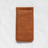 A brown leather phone pouch with a stitched border and a small debossed logo near the bottom, displayed on a textured white background.