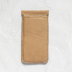 A tan leather phone pouch with a stitched top loop, displayed flat against a textured white background.