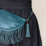 Teal leather tassel keychain on a white textured background
