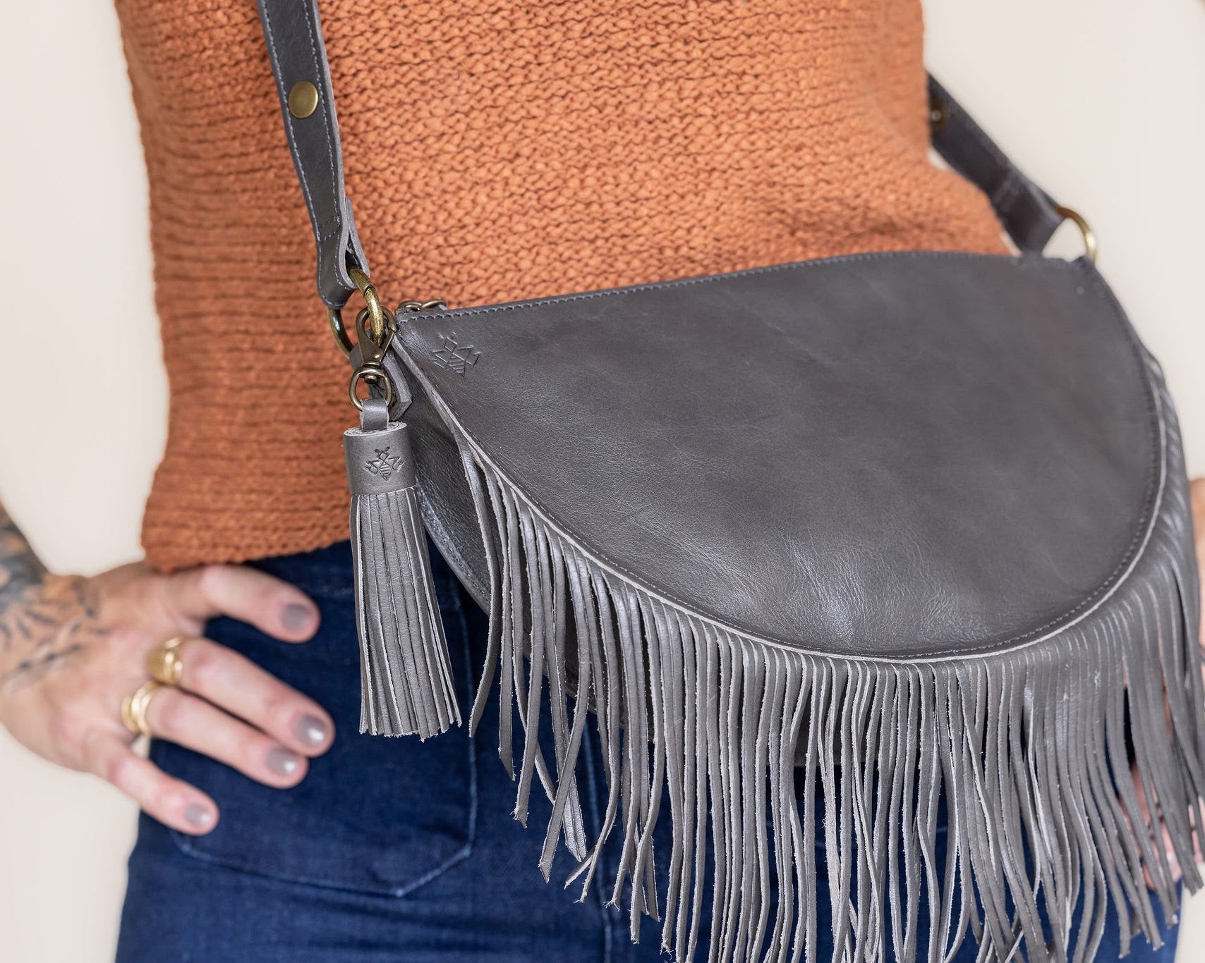 Charcoal leather tassel keychain on a white textured background