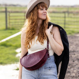 Woman wearing a hat and carrying a bag in an outdoor setting