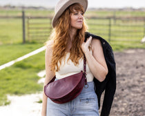 Woman wearing a hat and carrying a bag in an outdoor setting