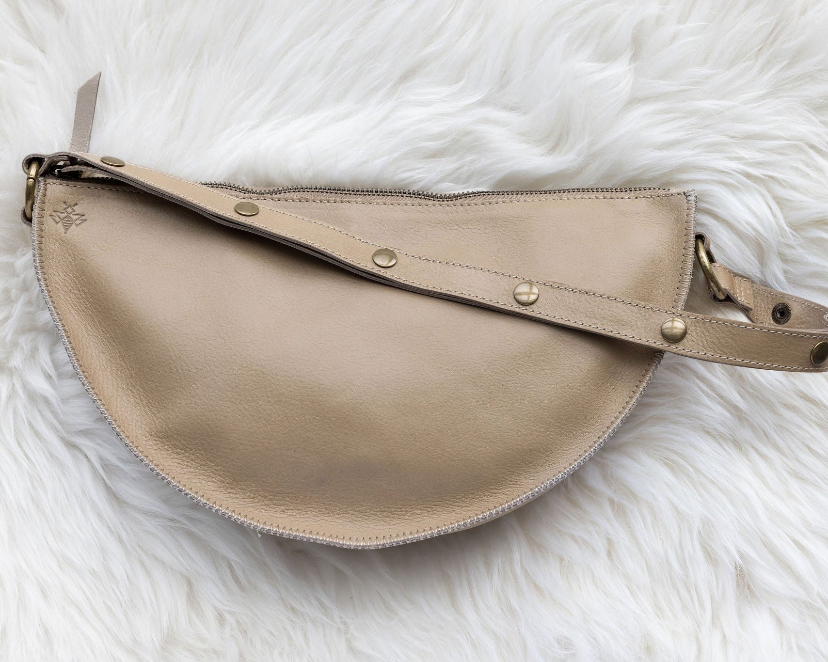Beige handbag on a white fluffy surface