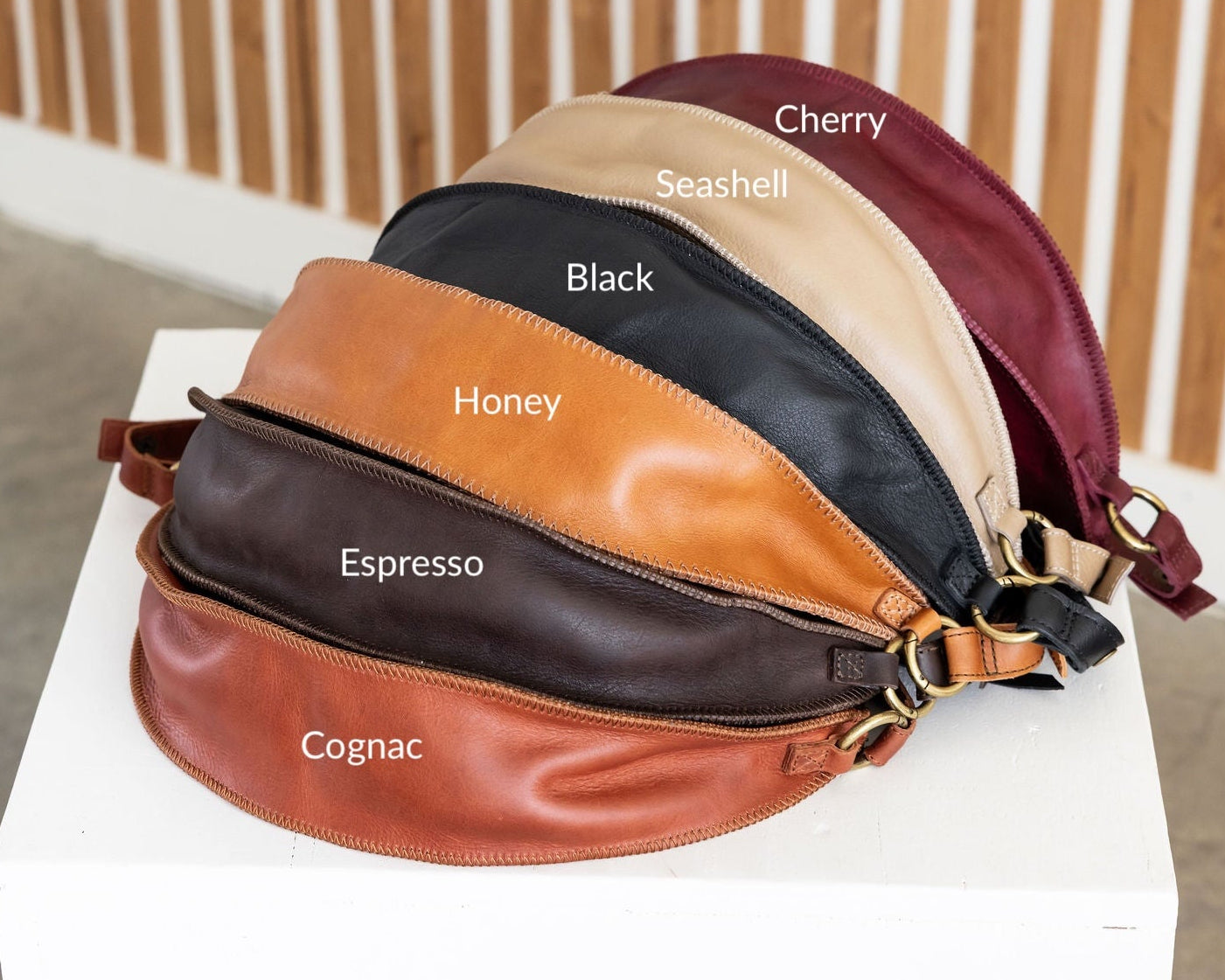 Leather bag with color swatches labeled on a white surface.