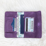 Purple wallet with cards and a passport on a white fur surface
