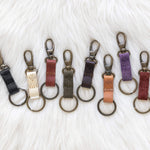 Set of keychains in various colors on a textured white background