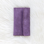 Purple wallet on a textured white surface