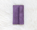 Purple wallet on a textured white surface