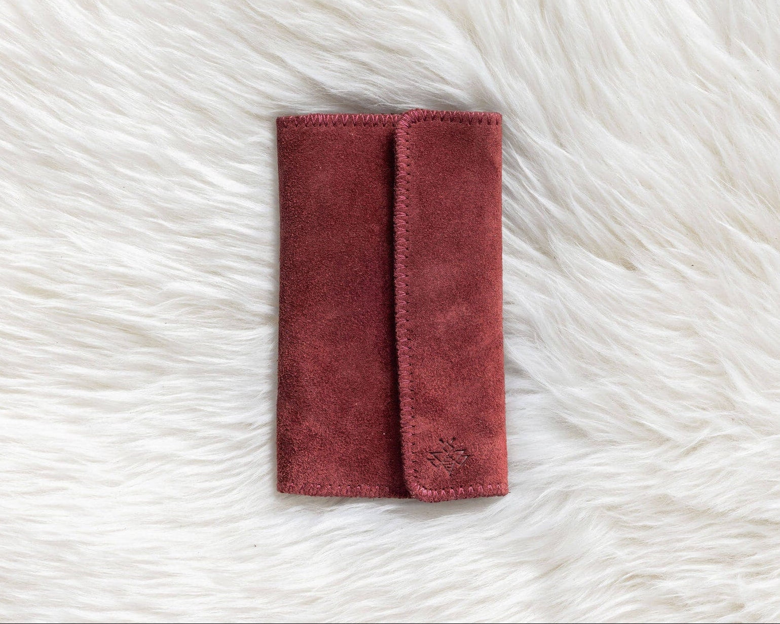Red fabric pouch on a white fluffy surface