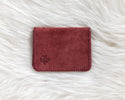 Red leather wallet on a white fur surface