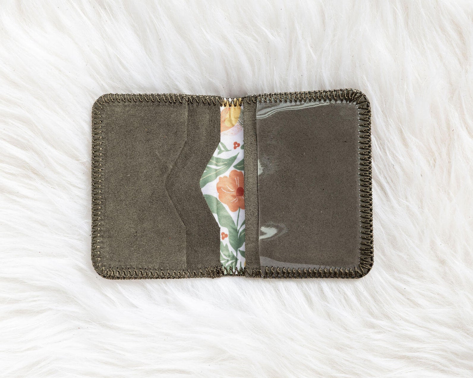 Gray fabric wallet with floral interior on a white textured background