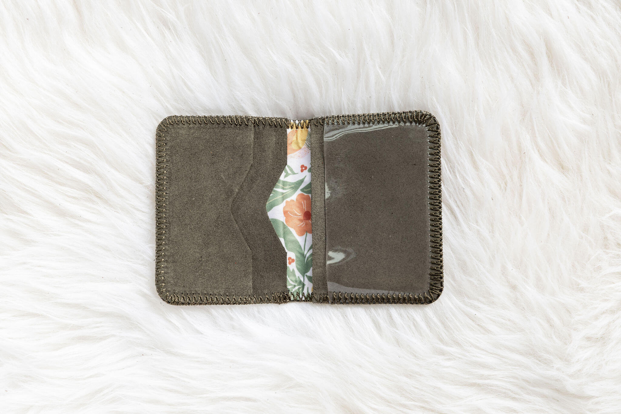 Gray fabric wallet with floral interior on a white textured background