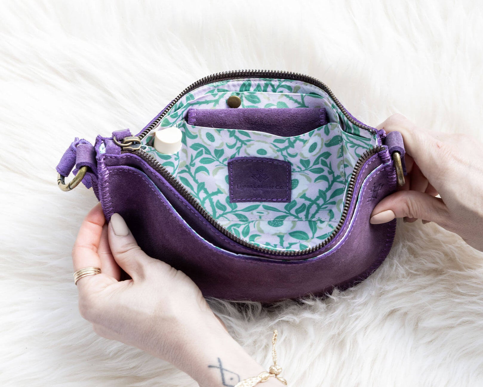 Purple handbag with floral pattern on a white fur surface