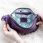 Purple handbag with floral pattern on a white fur surface