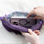 Person placing a phone with a purple case into a purple pouch on a white surface