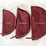 Three maroon pouches labeled 'The Bee', 'The Biggie Bee', and 'The Queen Bee' on a white fur background.