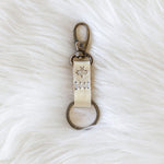 Keychain with engraved text on a white fur surface