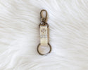 Keychain with engraved text on a white fur surface