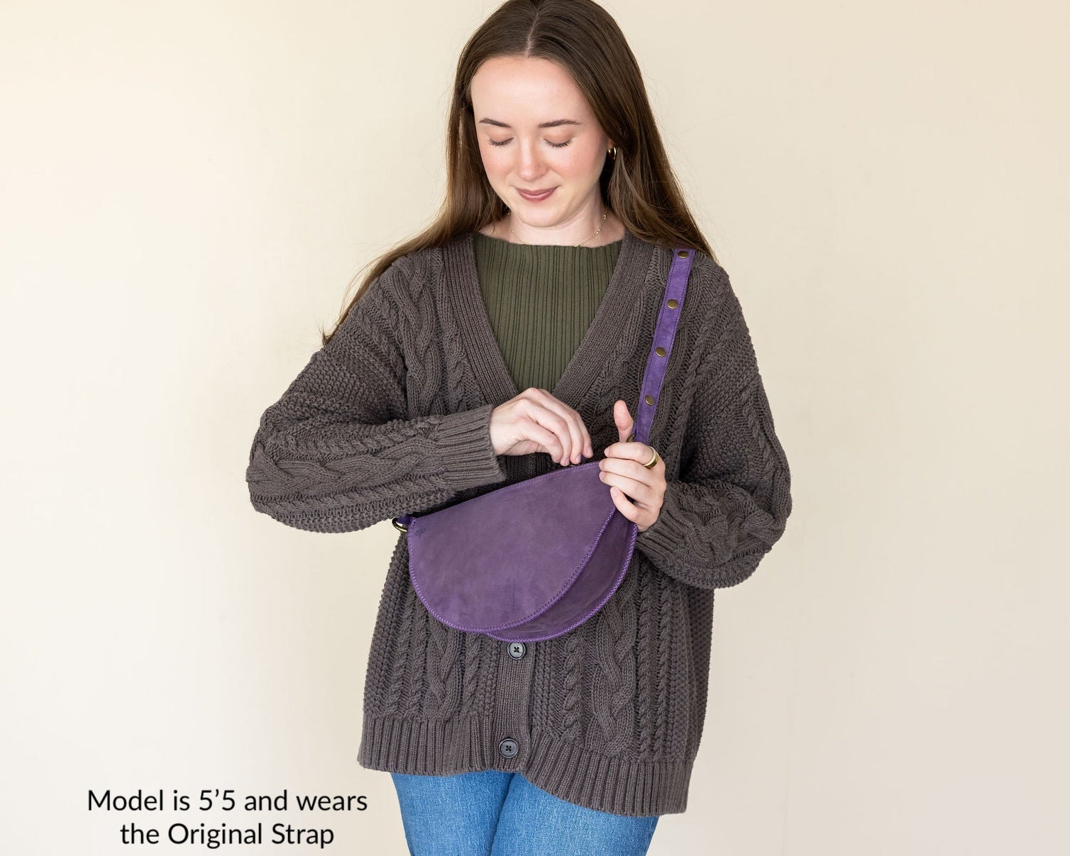 Woman holding a purple bag against a beige background