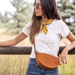Woman standing outdoors with a wooden fence and natural background