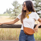 Woman standing outdoors with a wooden fence and natural background
