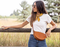 Woman standing outdoors with a wooden fence and natural background
