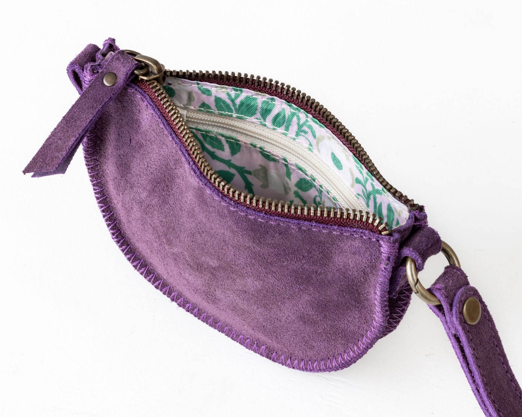 Purple suede clutch with floral interior on a white background