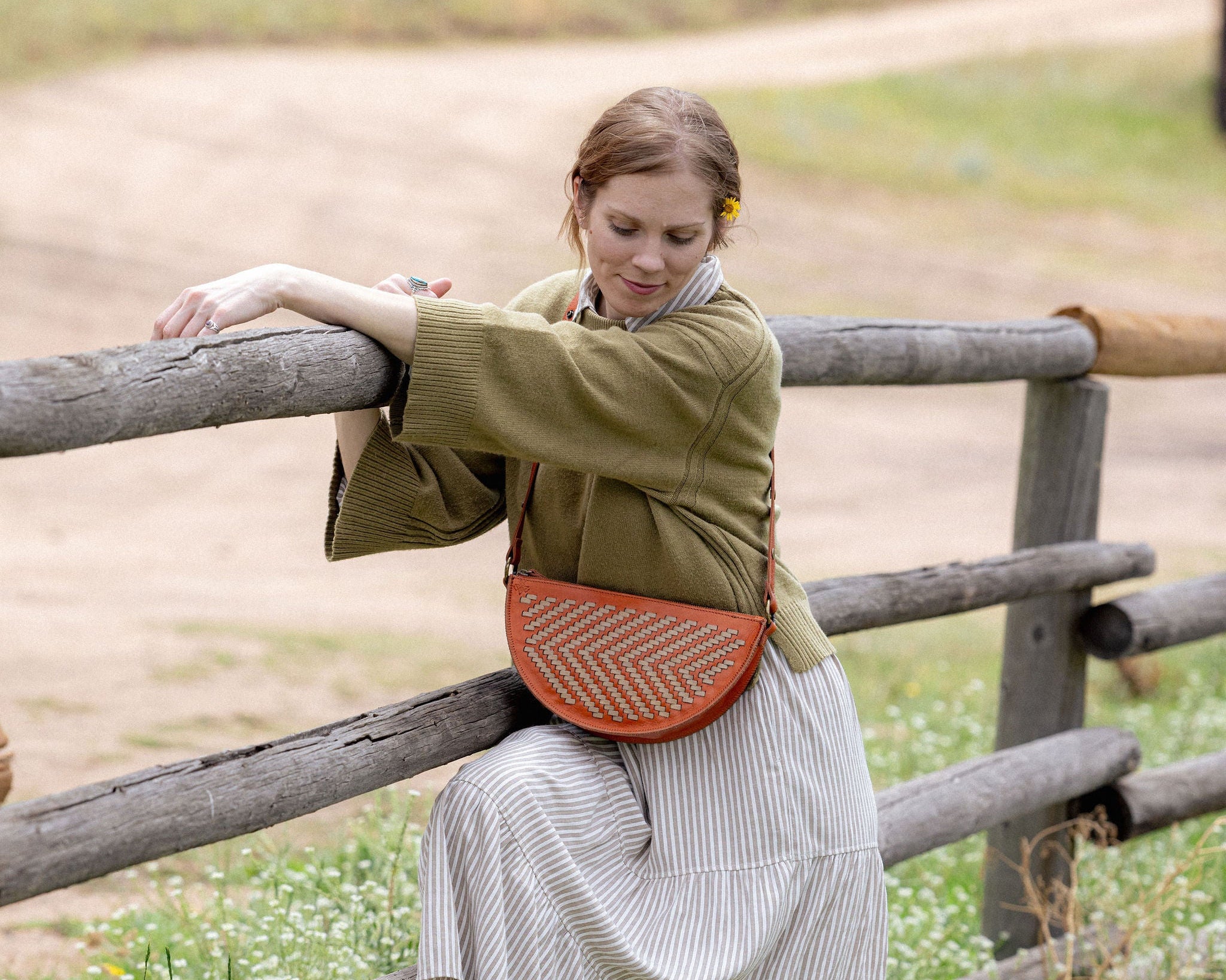 Woman wearing the Woven Terracotta & Seashell Biggie Bee crossbody in a mountain field