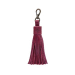 Maroon tassel keychain on a white textured background