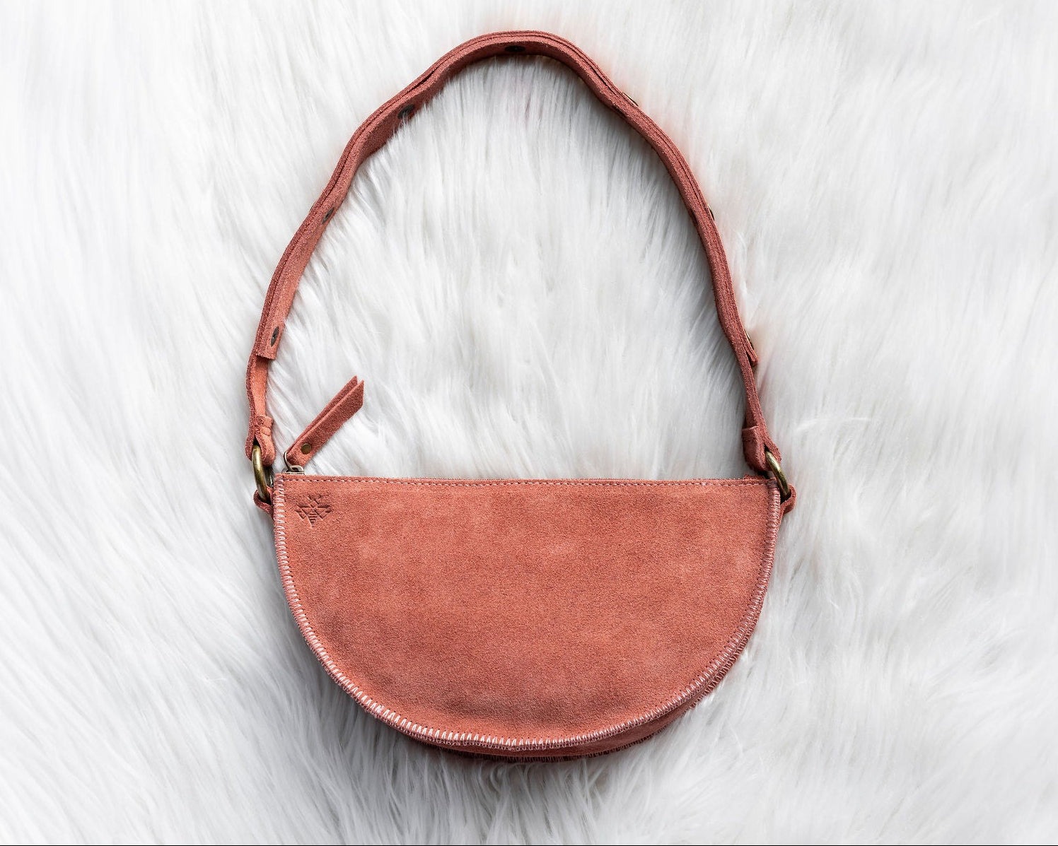 Mauve leather handbag on a white fur surface