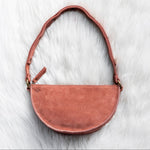 Mauve leather handbag on a white fur surface