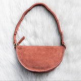 Mauve leather handbag on a white fur surface