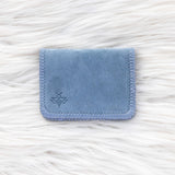 Blue fabric cardholder on a white textured background