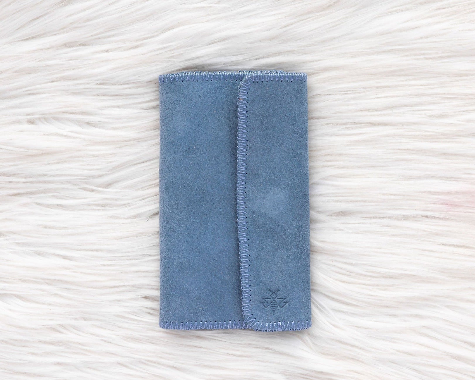 Blue fabric pouch on a textured white surface