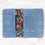 Blue fabric wallet with floral interior lining on a white background