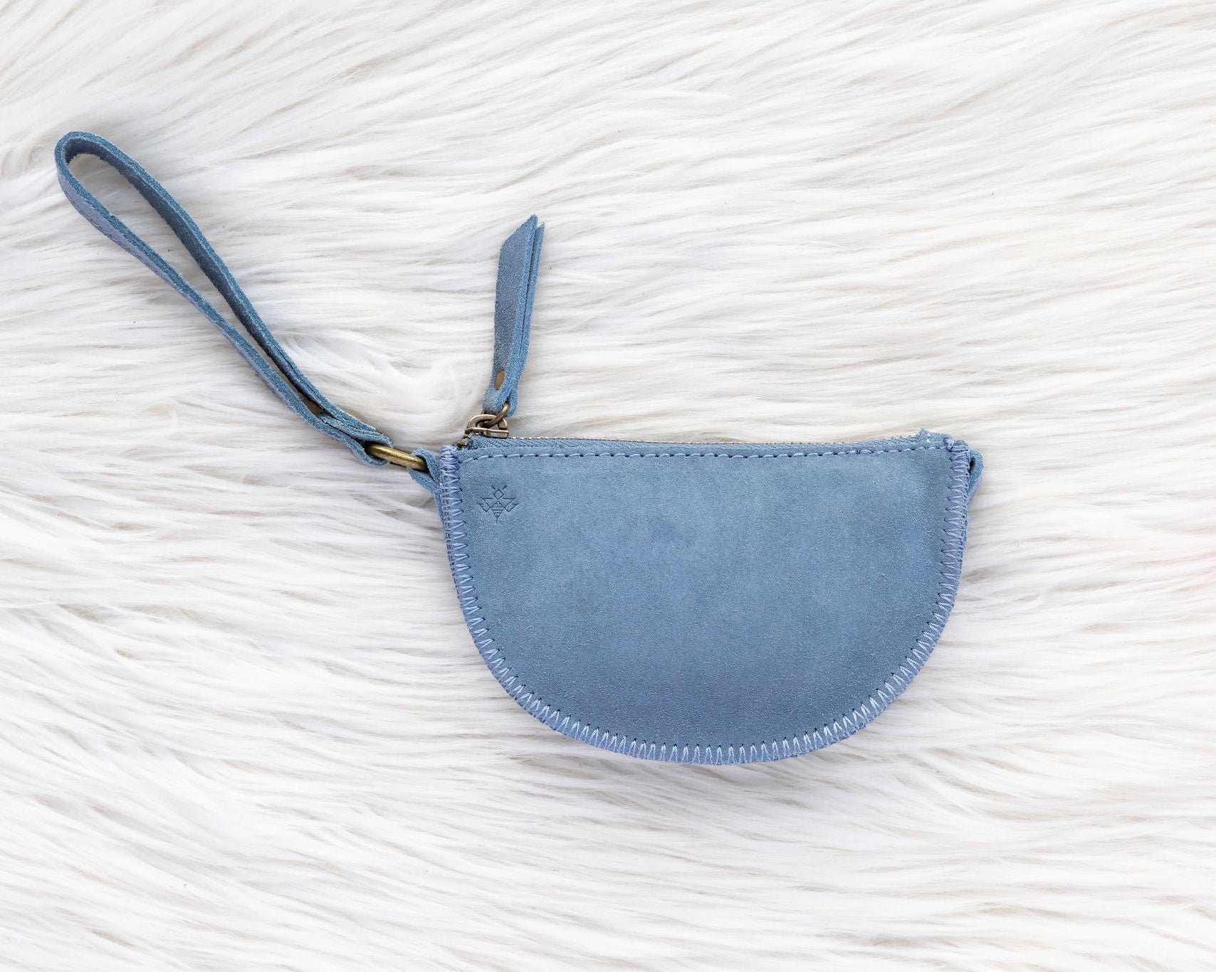 Blue wristlet purse on a textured white surface