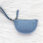 Blue wristlet purse on a textured white surface