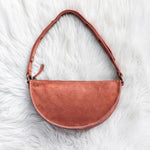 Mauve leather handbag on a white fur surface