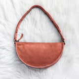 Mauve leather handbag on a white fur surface