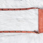 Mauve leather saddle pad on a white fur surface